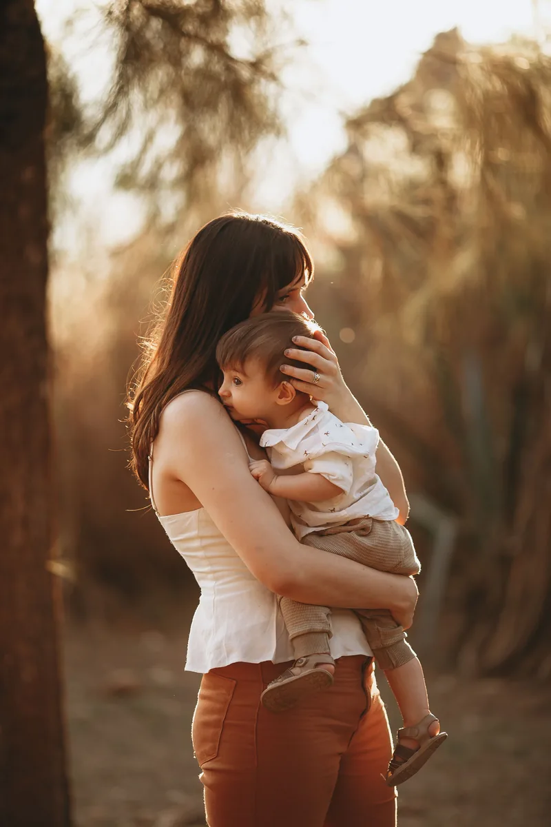 A mother holding her child in evening light